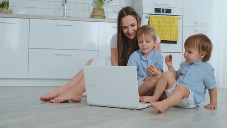 Eine-Fortschrittliche-Junge-Mutter-Mit-Zwei-Kleinen-Kindern-Spricht-Per-Videokommunikation-Mit-Ihrem-Vater.-Moderne-Technologie-Ist-Eine-Junge-Familie.